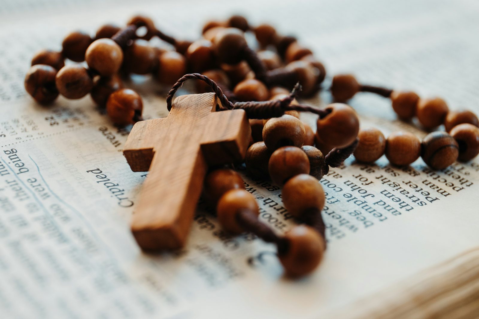 Wooden rosary resting on an open Bible
